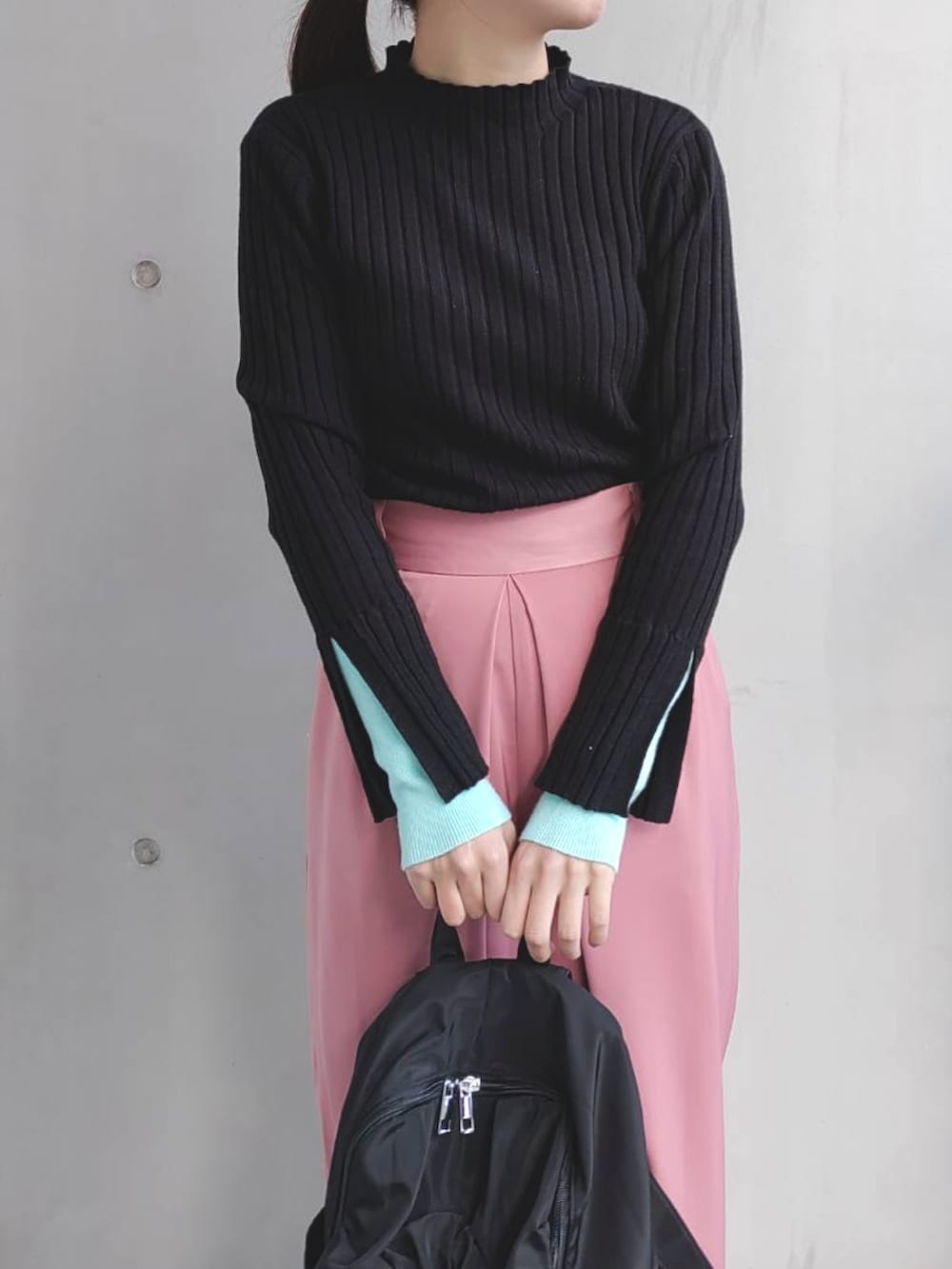 ブラック系のニット/セーター、ピンク系のその他パンツ、ホワイト系のスニーカーを着用したレディースの冬コーディネートの4枚目の写真