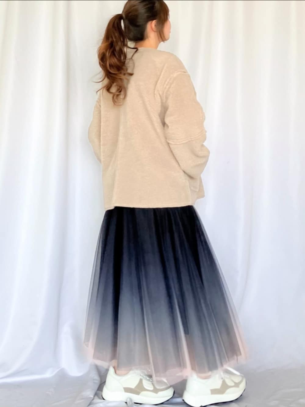 ブラック系のスカート、ホワイト系のスニーカー、ベージュ系のブルゾンを着用したレディースの冬コーディネートの4枚目の写真