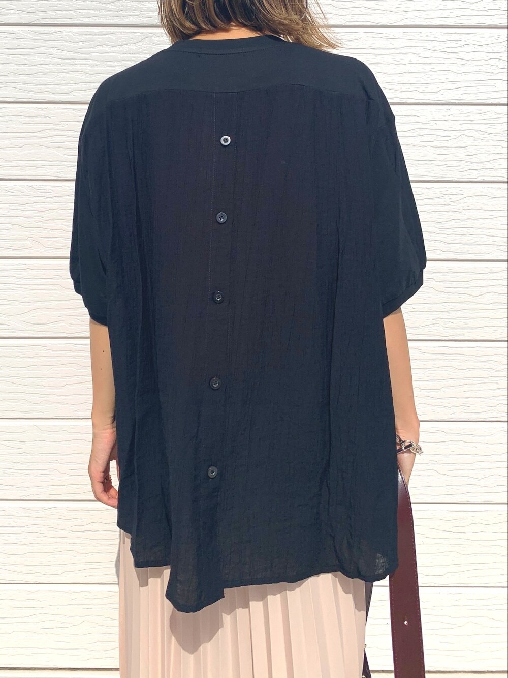 ベージュ系のスカート、ブラウン系のショルダーバッグ、ベージュ系のサンダルを着用したレディースの夏コーディネートの3枚目の写真