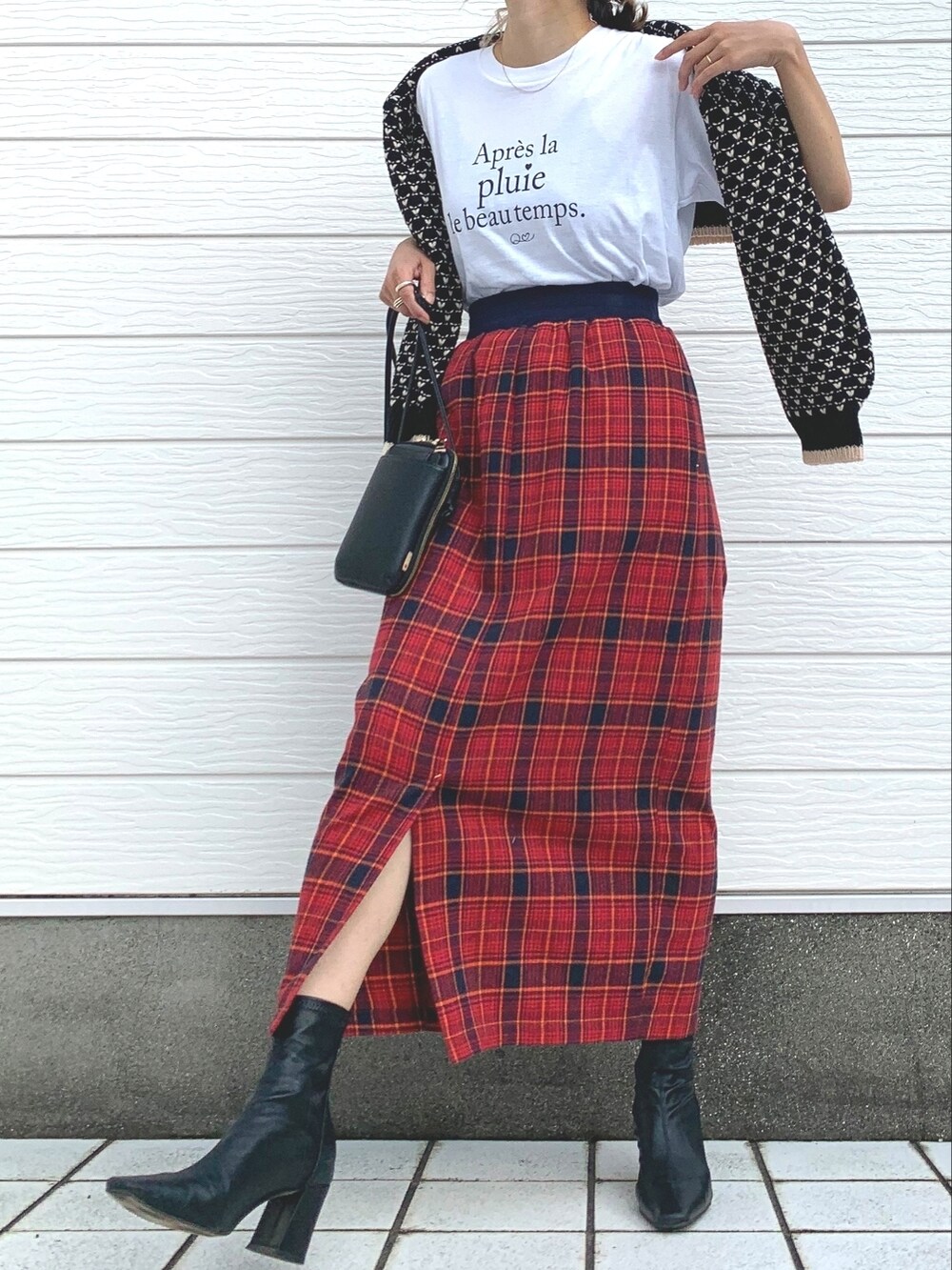 レッド系のスカート、ブラック系のショルダーバッグ、ホワイト系のTシャツ/カットソーを着用したレディースの秋コーディネートの2枚目の写真