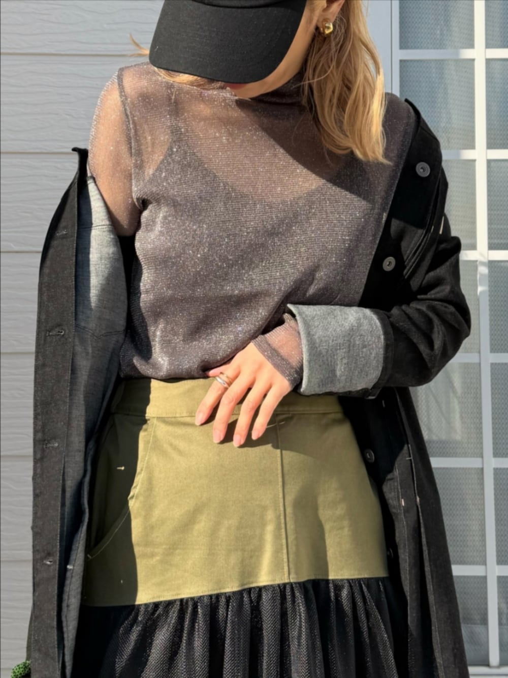 グリーン系のスカート、グリーン系のボストンバッグ、ブラック系のデニムジャケットを着用したレディースの冬コーディネートの5枚目の写真