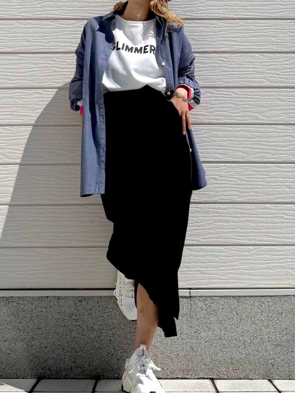 ブラック系のスカート、ブルー系のシャツ/ブラウス、ホワイト系のTシャツ/カットソーを着用したレディースの春コーディネートの2枚目の写真