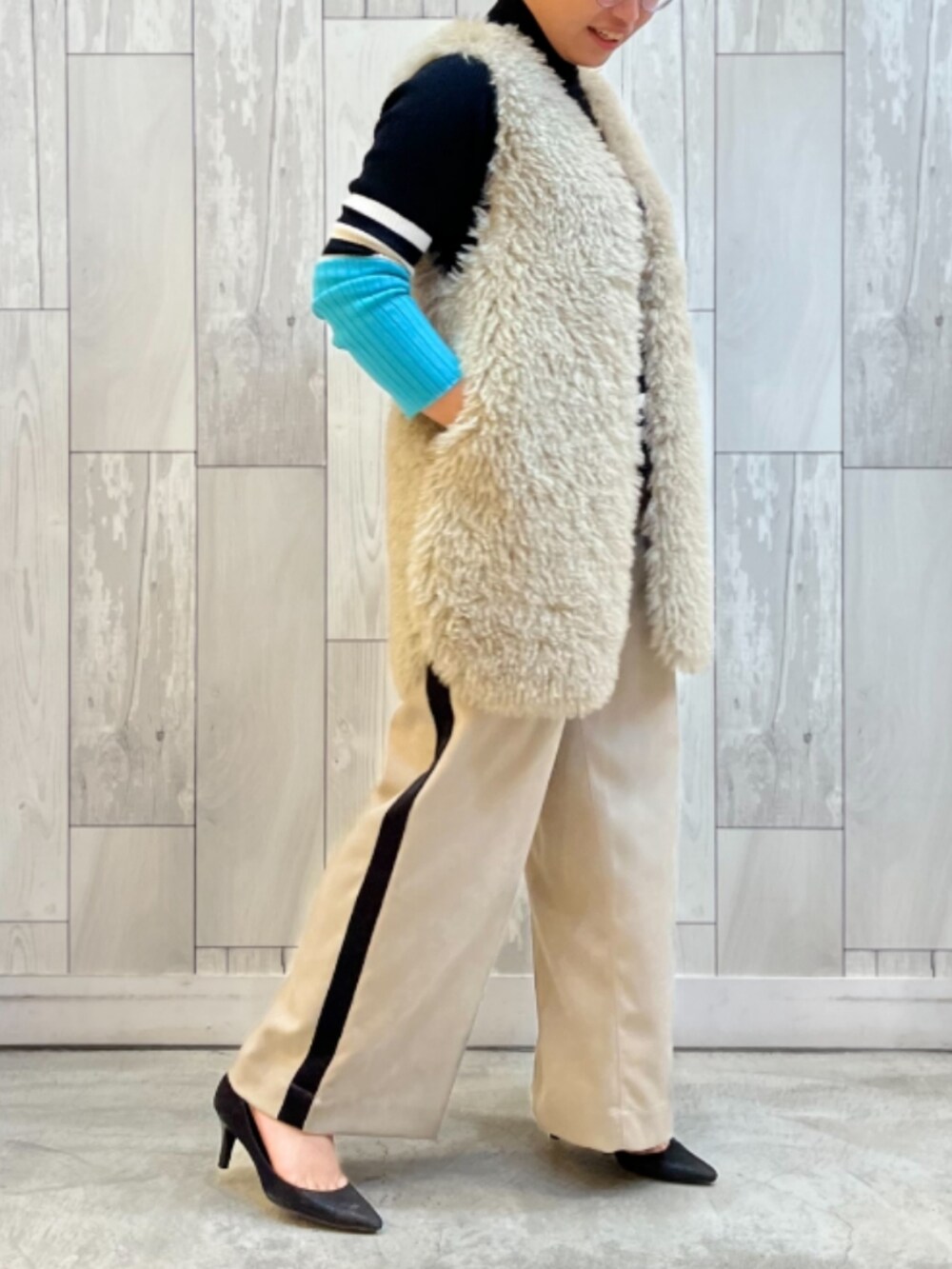 ベージュ系のその他パンツ、ブラック系のニット/セーター、ベージュ系のベストを着用したレディースの冬コーディネートの2枚目の写真