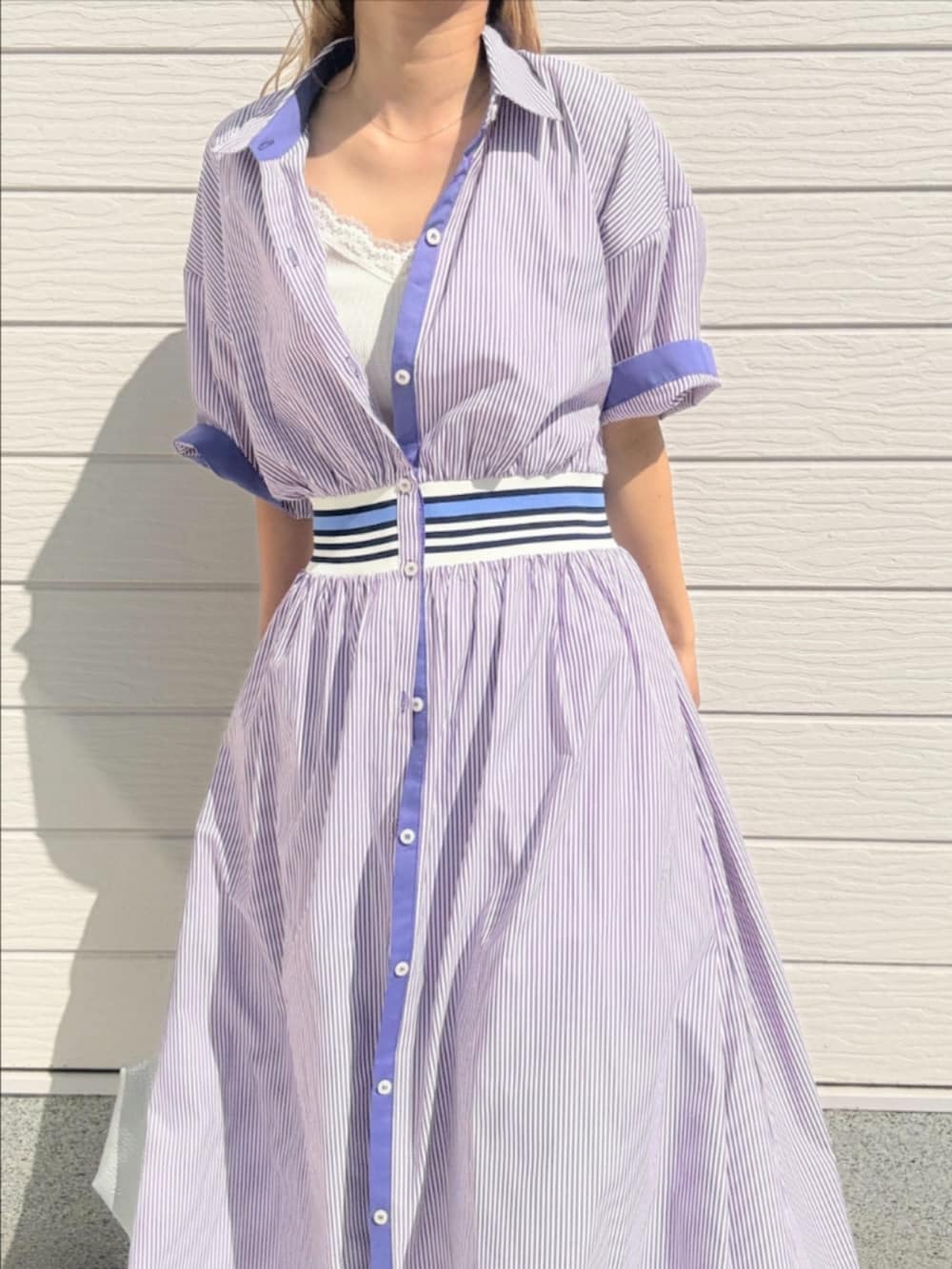 ブルー系のデニムパンツ、シルバー系のトートバッグ、パープル系のワンピースを着用したレディースの春コーディネートの4枚目の写真