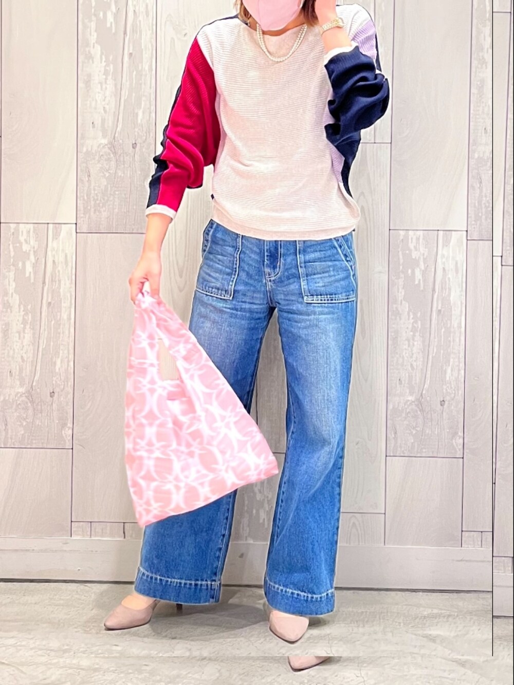 ブルー系のデニムパンツ、ブルー系のニット/セーター、ピンク系のエコバッグ/サブバッグを着用したレディースの冬コーディネートの3枚目の写真