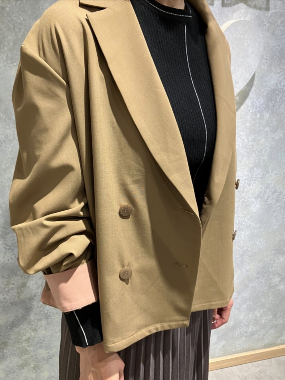 グリーン系のスカート、ブラウン系のテーラードジャケット、ブラック系のニット/セーターを着用したレディースの秋コーディネートの4枚目の写真