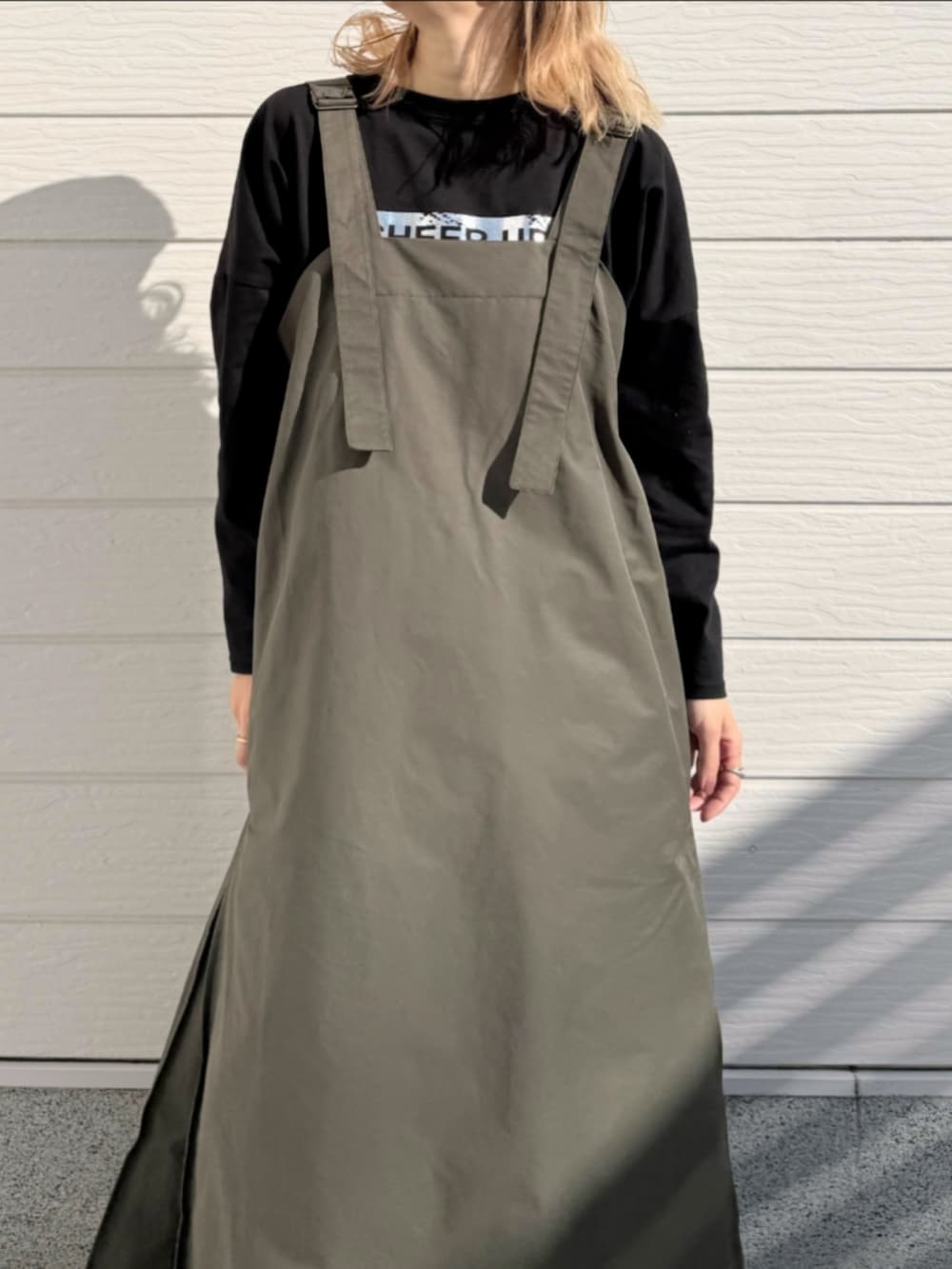 グリーン系のワンピース、ホワイト系のスニーカー、シルバー系のトートバッグを着用したレディースの冬コーディネートの4枚目の写真