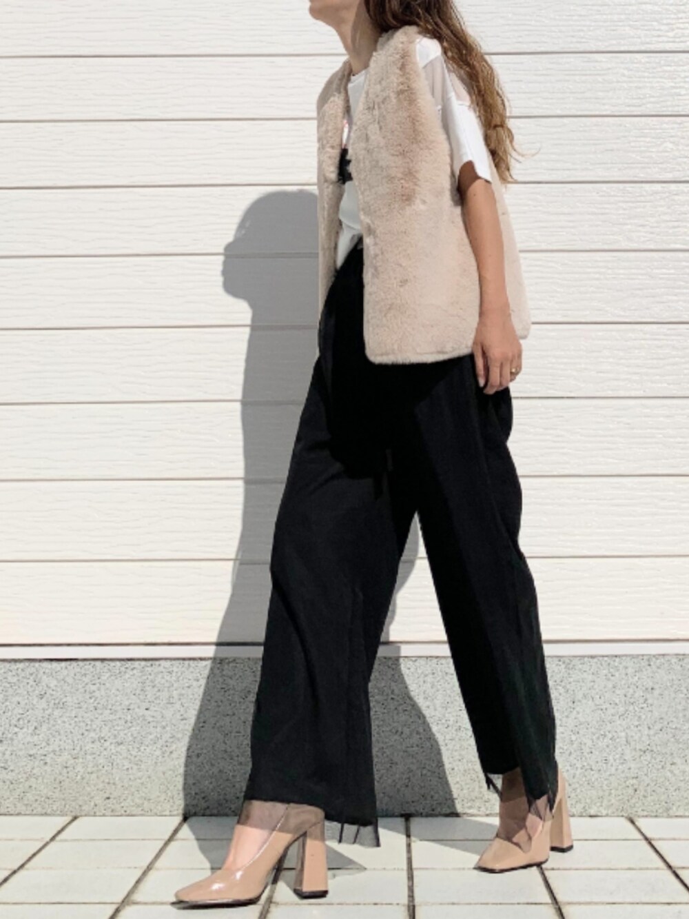 ベージュ系のベスト、ホワイト系のTシャツ/カットソー、ブラック系のその他パンツを着用したレディースの秋コーディネートの2枚目の写真