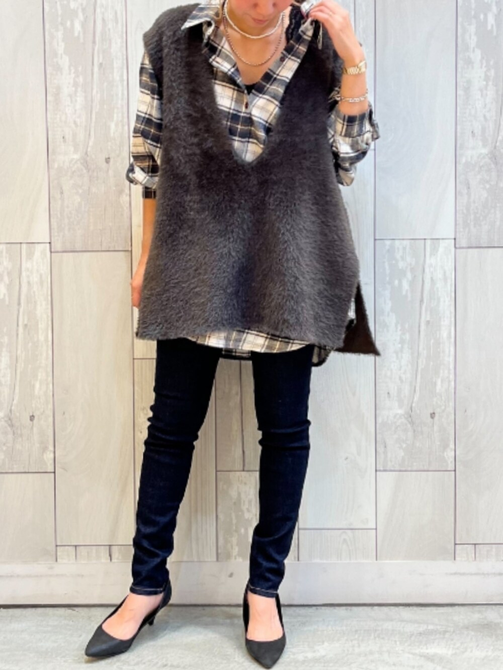 ブルー系のデニムパンツ、ブラウン系のベスト、ブルー系のシャツ/ブラウスを着用したレディースの秋コーディネートの2枚目の写真