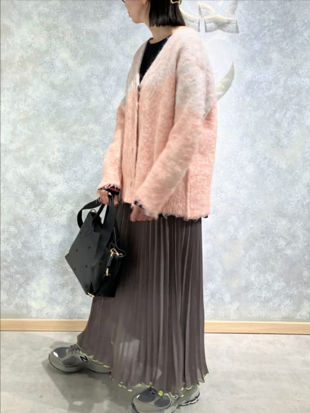 グリーン系のスカート、ブラック系のトートバッグ、ブラック系のTシャツ/カットソーを着用したレディースの冬コーディネートの3枚目の写真