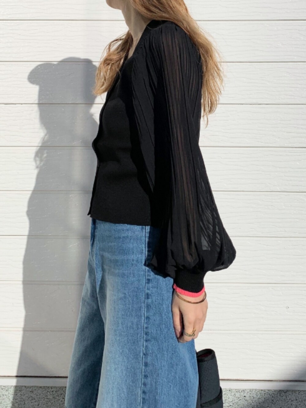 ブルー系のデニムパンツ、ホワイト系のスニーカー、ブルー系のトートバッグを着用したレディースの冬コーディネートの4枚目の写真