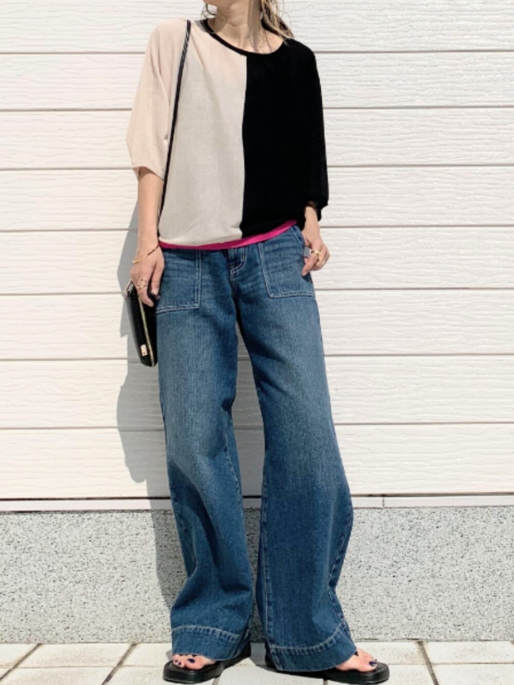 ブルー系のデニムパンツ、ブラック系のショルダーバッグ、ブラック系のニット/セーターを着用したレディースの春コーディネートの2枚目の写真