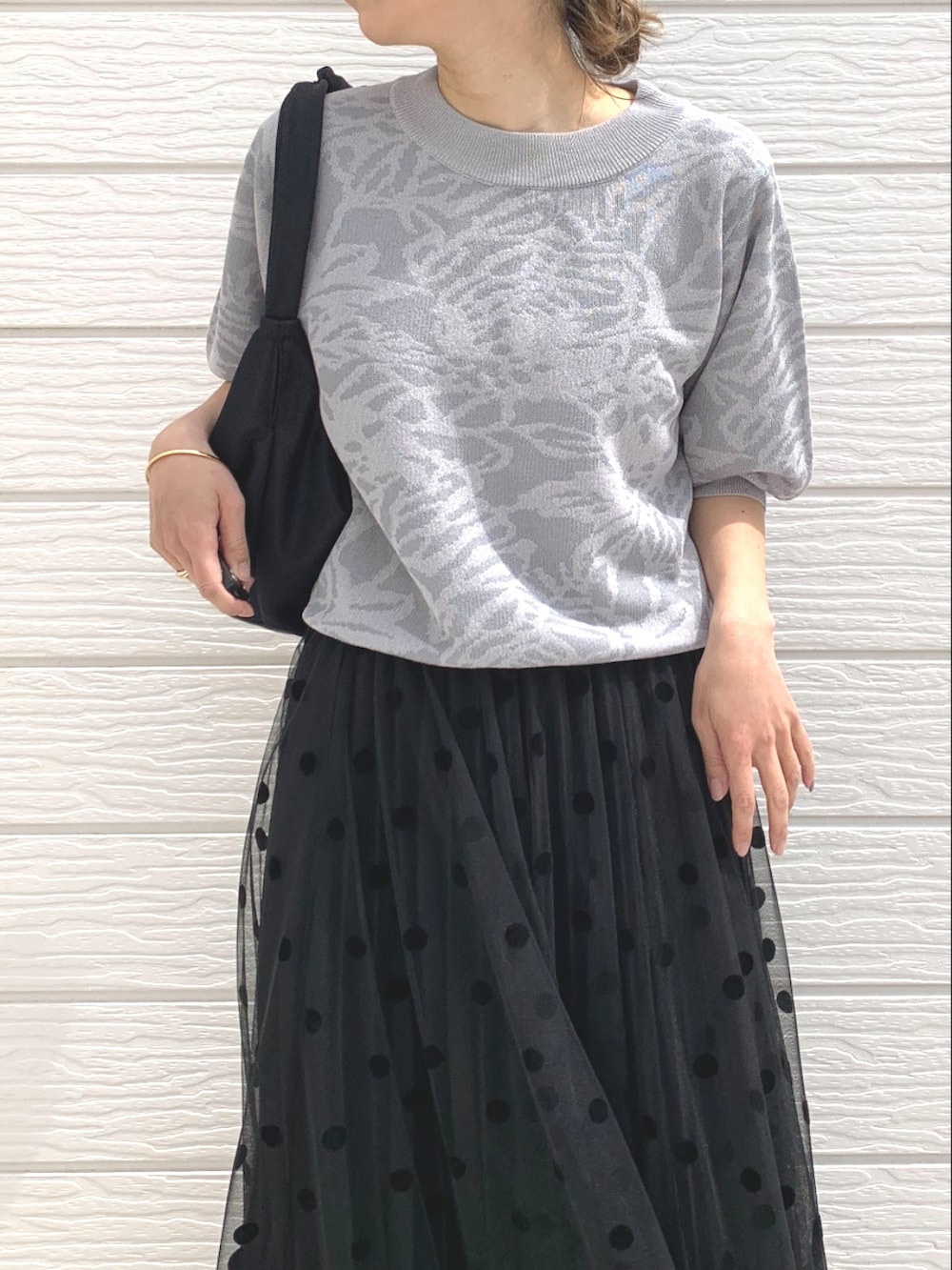 ブラック系のスカート、ブラック系のサンダル、ブラック系のショルダーバッグを着用したレディースの春コーディネートの3枚目の写真