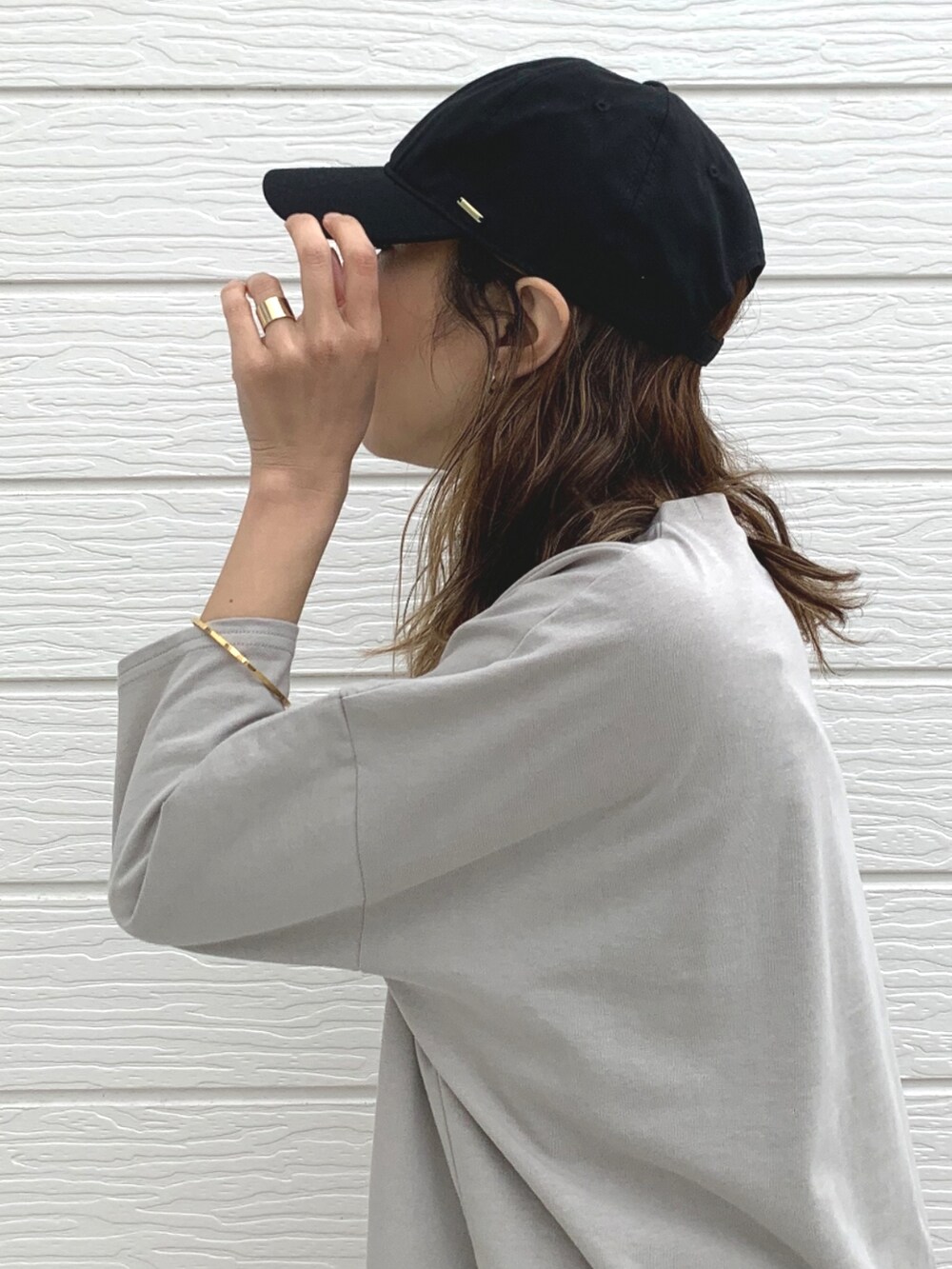 オレンジ系のハンドバッグ、ベージュ系のTシャツ/カットソー、ブラック系のスカートを着用したレディースの春コーディネートの5枚目の写真