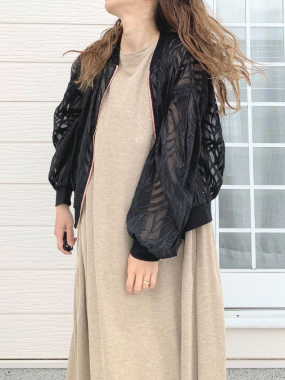 ブラック系のショルダーバッグ、ベージュ系のワンピース、ブラック系のブルゾンを着用したレディースの春コーディネートの4枚目の写真