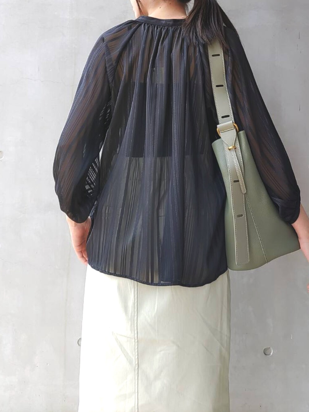 ブラック系のシャツ/ブラウス、グリーン系のスカート、ブラック系のサンダルを着用したレディースの春コーディネートの4枚目の写真