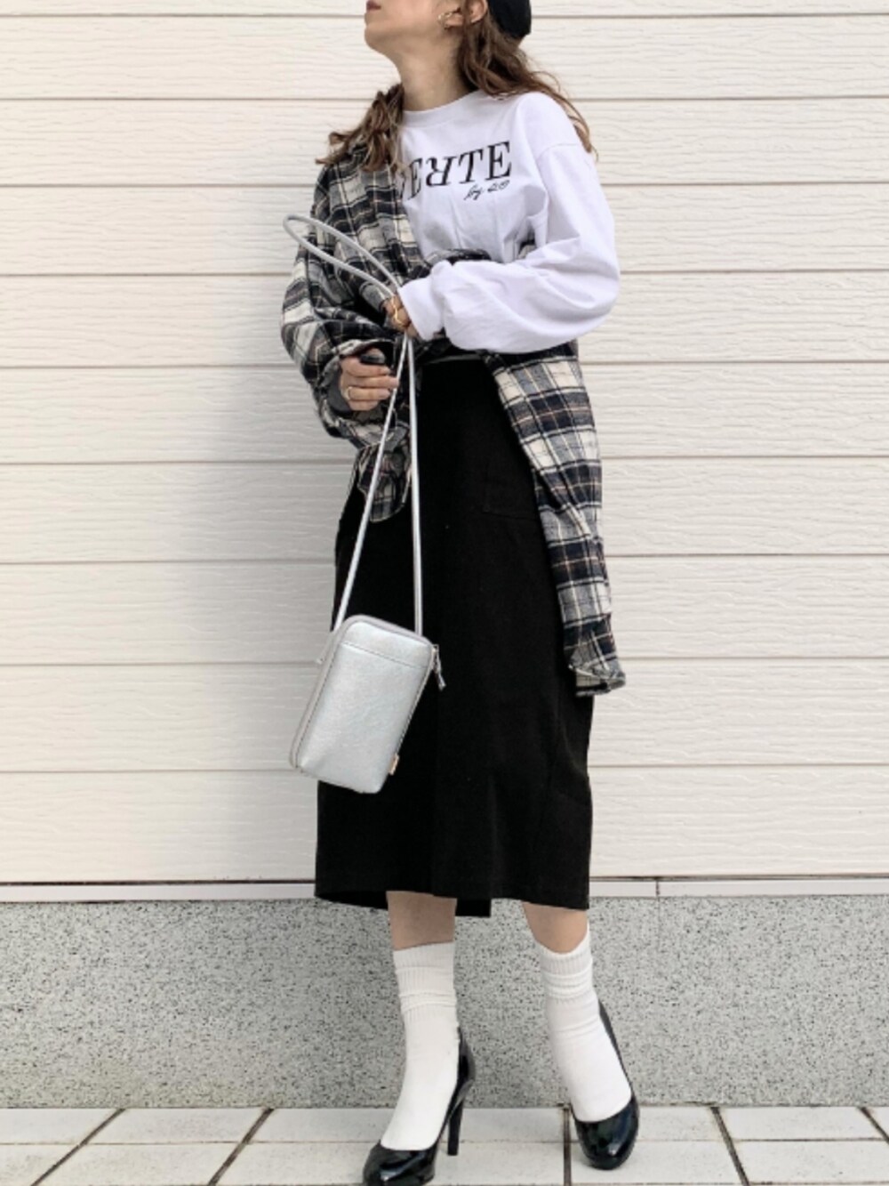 ホワイト系のTシャツ/カットソー、ブラック系のスカート、シルバー系のショルダーバッグを着用したレディースの秋コーディネートの2枚目の写真