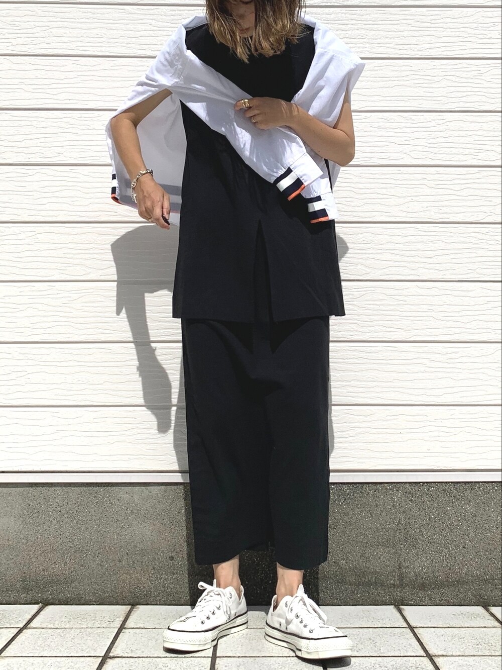 ブラック系のワンピース、ホワイト系のシャツ/ブラウス、ホワイト系のスニーカーを着用したレディースの夏コーディネートの2枚目の写真