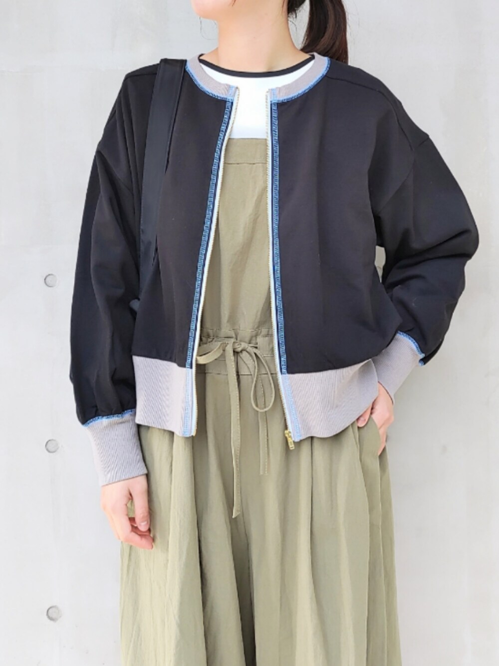 ブラック系のスニーカー、ブラック系のバックパック/リュック、グリーン系のサロペット/オーバーオールを着用したレディースの冬コーディネートの3枚目の写真