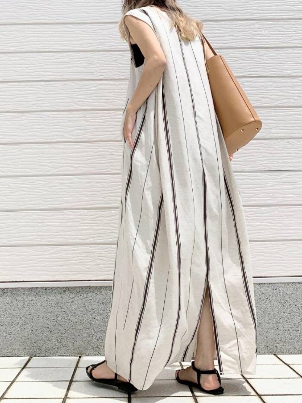 ベージュ系のトートバッグ、グリーン系のワンピースを着用したレディースの春コーディネートの2枚目の写真