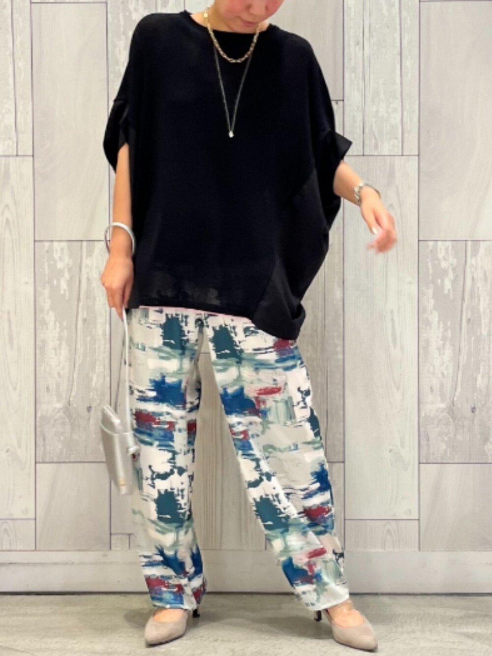 グリーン系のその他パンツ、ブラック系のニット/セーター、シルバー系のショルダーバッグを着用したレディースの夏コーディネートの2枚目の写真