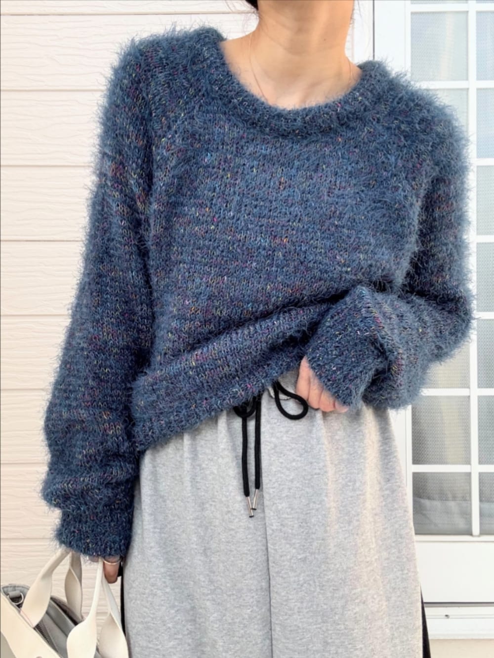 グレー系のトートバッグ、ブラック系のブーツ、グレー系のスカートを着用したレディースの秋コーディネートの4枚目の写真