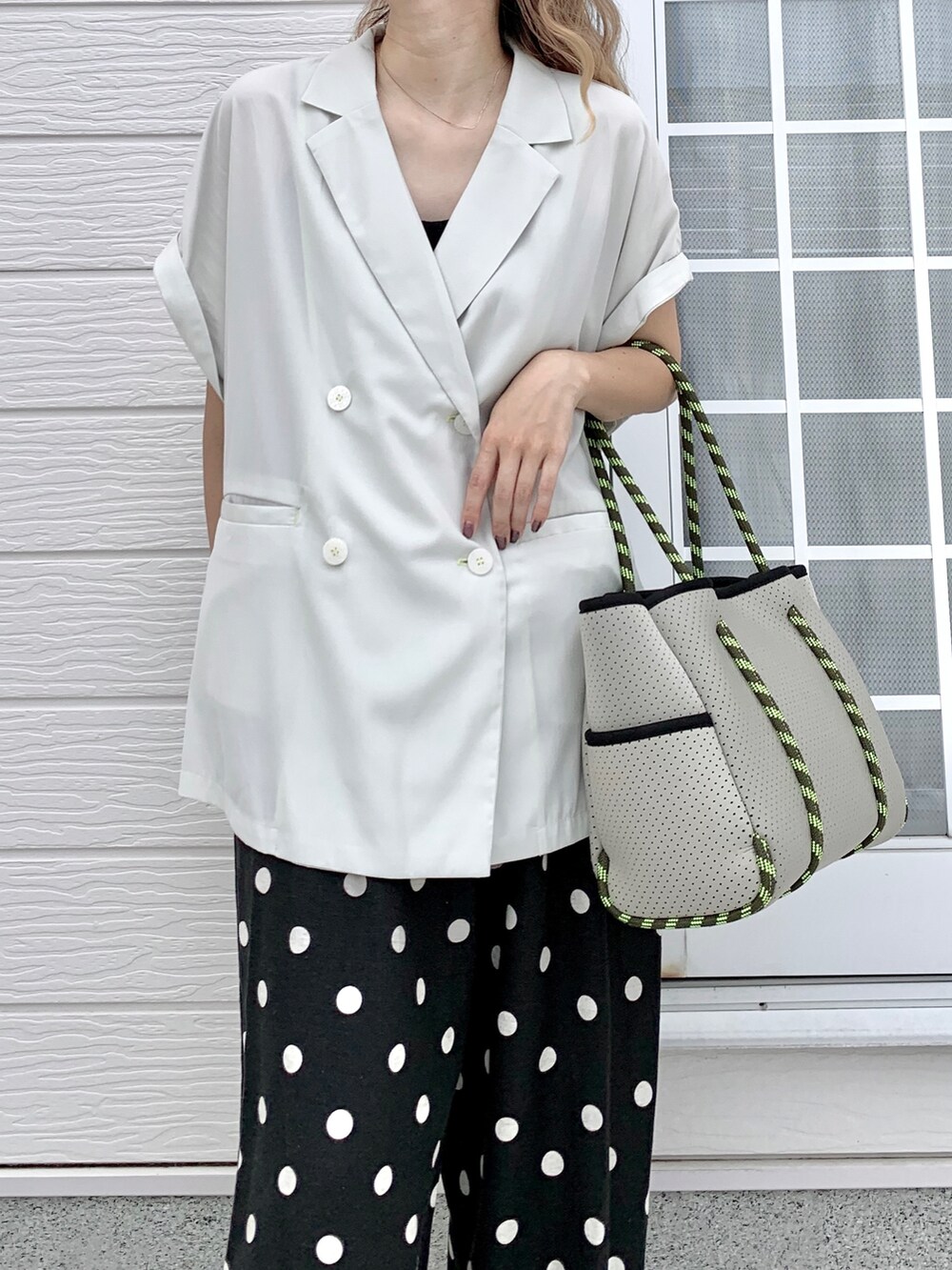 グレー系のトートバッグ、ブラック系のその他パンツ、ベージュ系のテーラードジャケットを着用したレディースの夏コーディネートの2枚目の写真