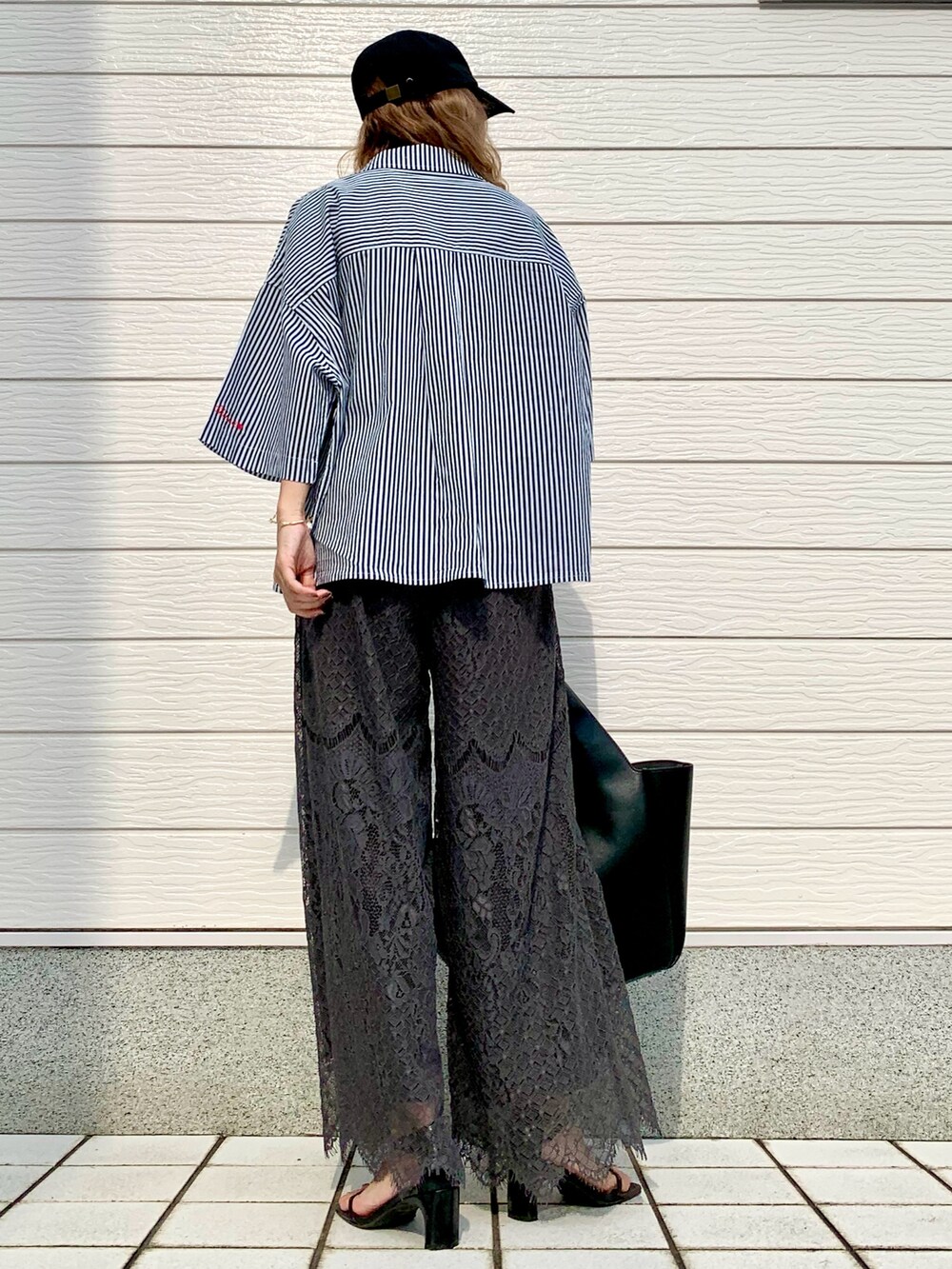 ブルー系のシャツ/ブラウス、ブラック系のトートバッグ、グレー系のその他パンツを着用したレディースの夏コーディネートの3枚目の写真