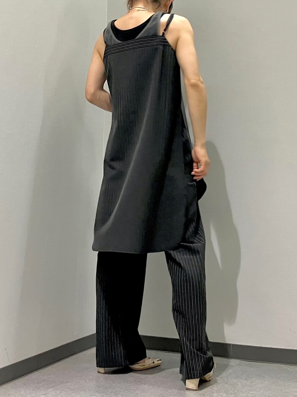 ブラック系のスラックス、ブラック系のタンクトップ、ブラック系のチュニックを着用したレディースの夏コーディネートの4枚目の写真