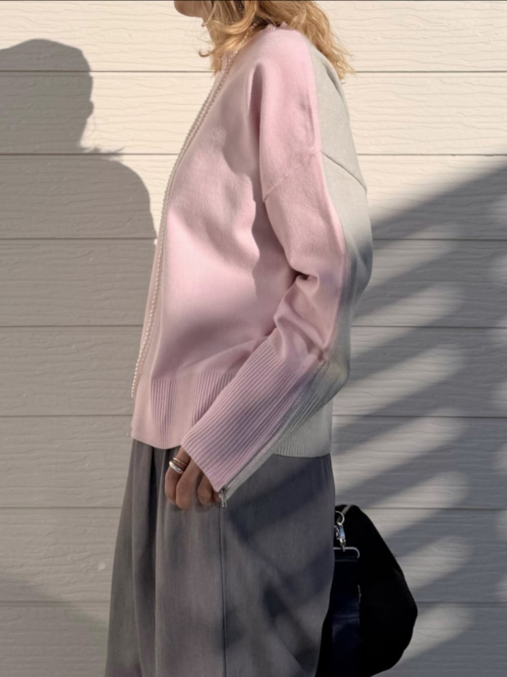 ホワイト系のスニーカー、グレー系のスラックス、ピンク系のニット/セーターを着用したレディースの冬コーディネートの4枚目の写真