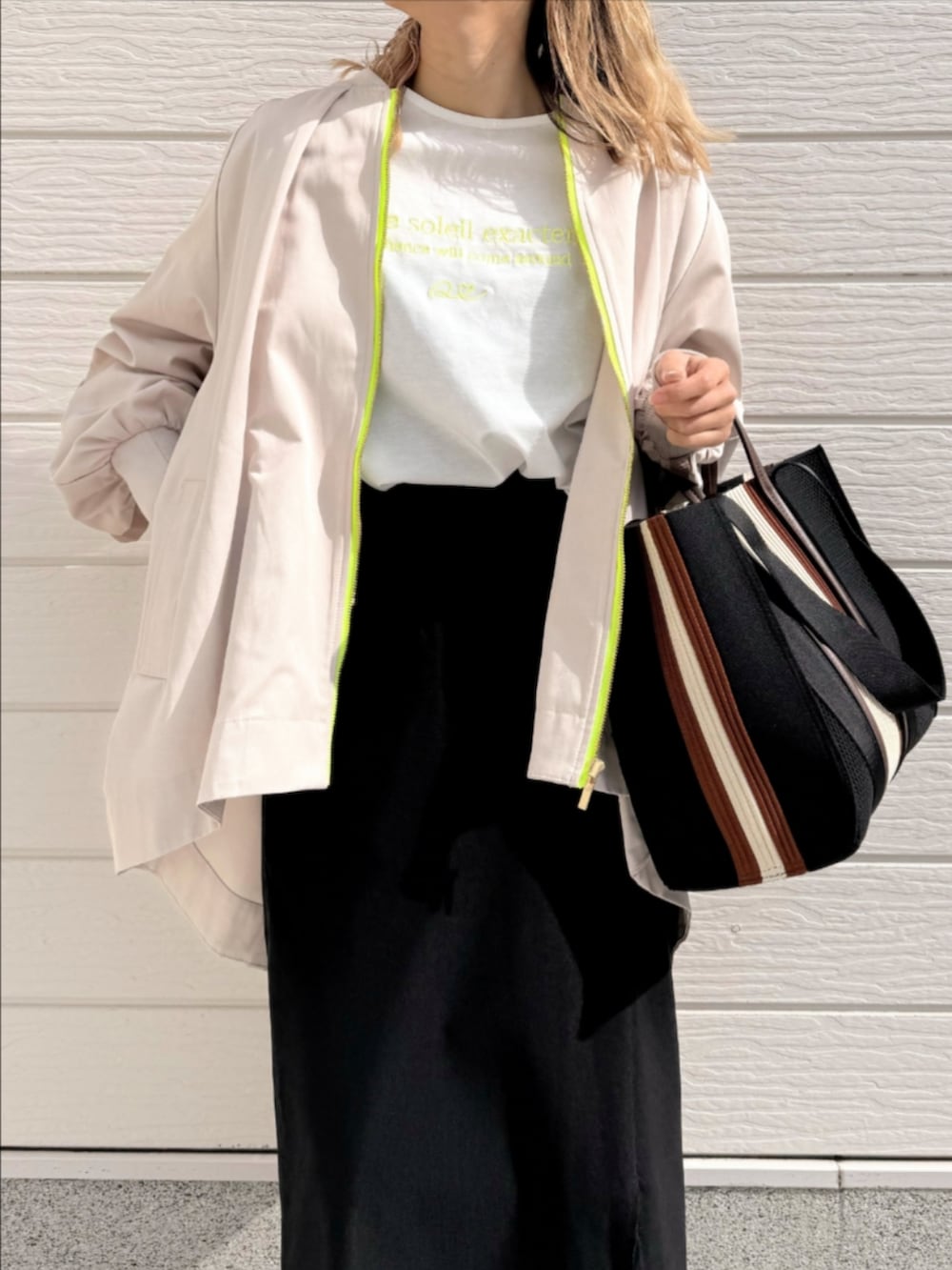 ブラック系のトートバッグ、ブラック系のサンダル、ブラック系のスカートを着用したレディースの冬コーディネートの3枚目の写真