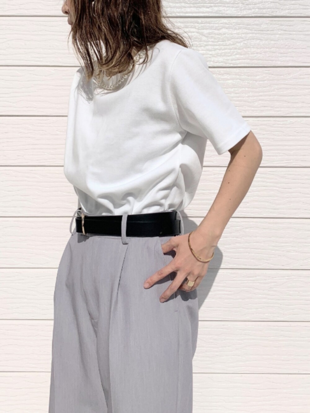グレー系のその他パンツ、ホワイト系のTシャツ/カットソー、シルバー系のハンドバッグを着用したレディースの春コーディネートの4枚目の写真