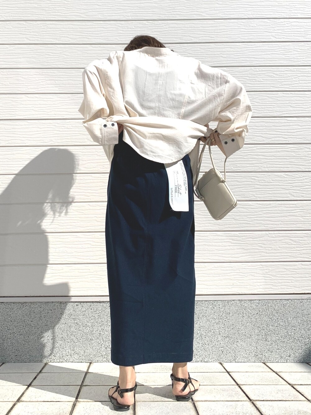 ホワイト系のショルダーバッグ、ブルー系のスカート、ホワイト系のシャツ/ブラウスを着用したレディースの冬コーディネートの3枚目の写真