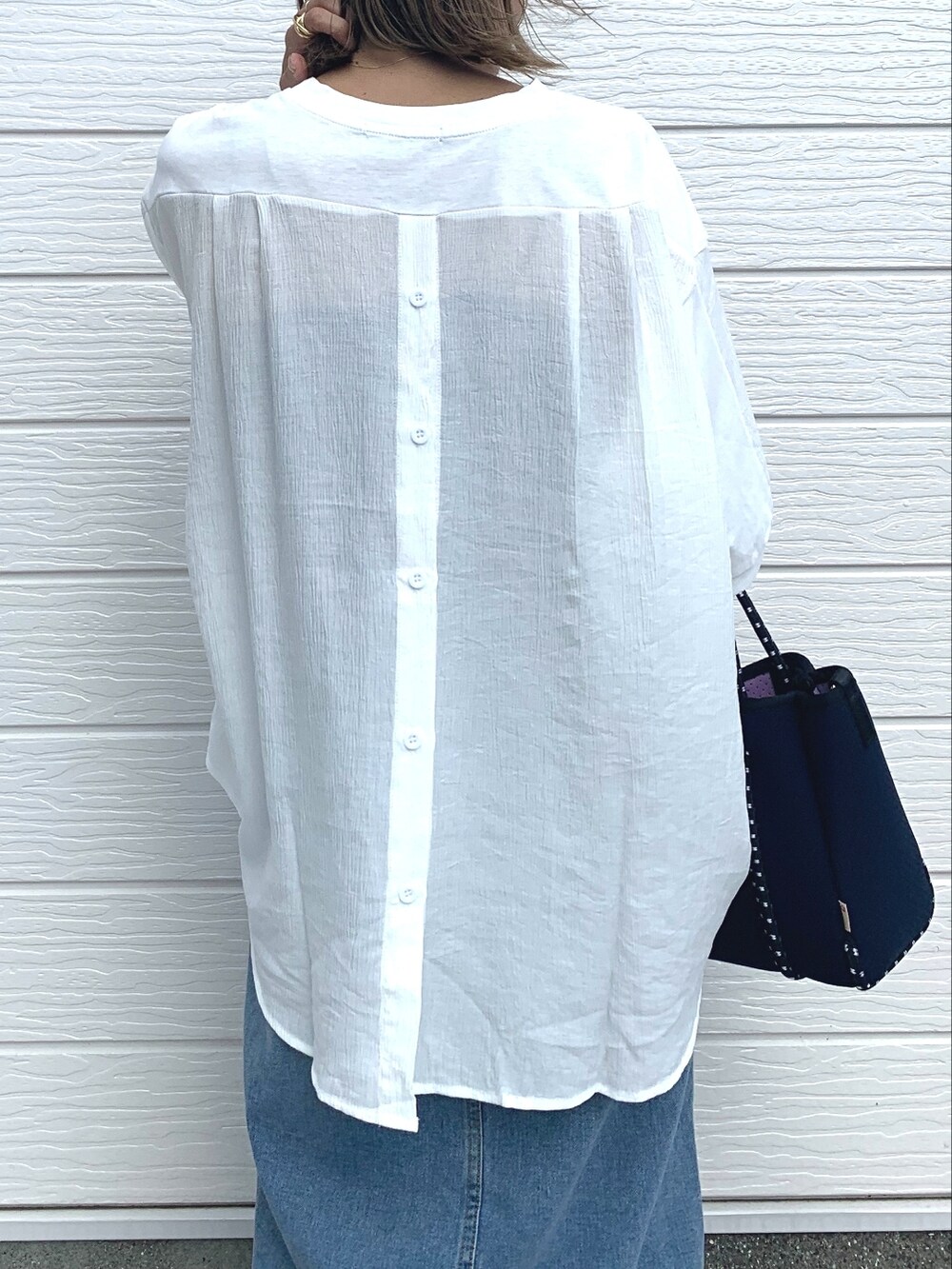 ブルー系のデニムスカート、ブルー系のトートバッグ、ホワイト系のTシャツ/カットソーを着用したレディースの夏コーディネートの2枚目の写真