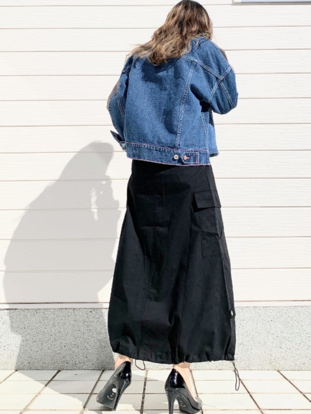 ホワイト系のTシャツ/カットソー、ブルー系のデニムジャケット、ブラック系のスカートを着用したレディースの春コーディネートの4枚目の写真