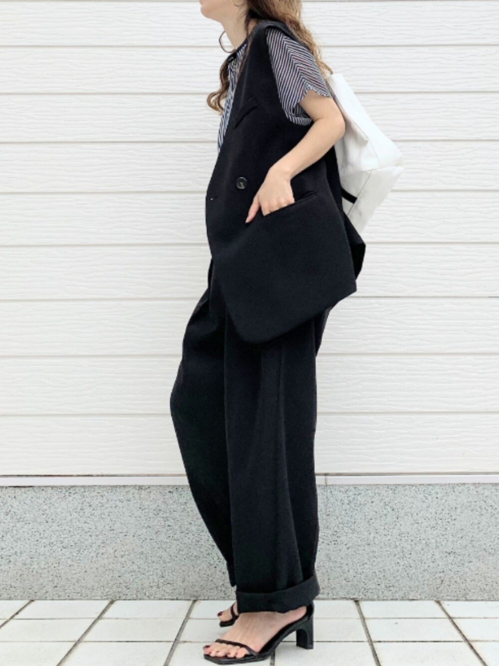 ブラック系のその他パンツ、ホワイト系のトートバッグ、ブルー系のシャツ/ブラウスを着用したレディースの春コーディネートの2枚目の写真