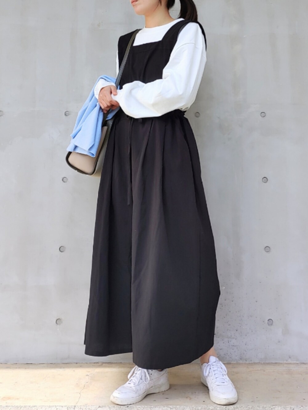 ホワイト系のトートバッグ、ホワイト系のスニーカー、ホワイト系のTシャツ/カットソーを着用したレディースの冬コーディネートの3枚目の写真