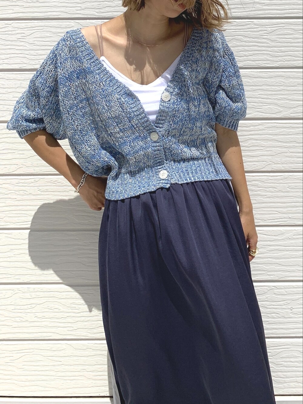 グレー系のスカート、ブルー系のカーディガン/ボレロ、ホワイト系のキャミソールを着用したレディースの夏コーディネートの2枚目の写真