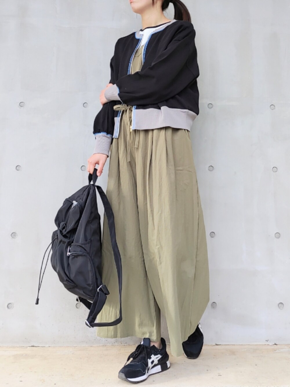 ブラック系のスニーカー、ブラック系のバックパック/リュック、グリーン系のサロペット/オーバーオールを着用したレディースの冬コーディネートの2枚目の写真