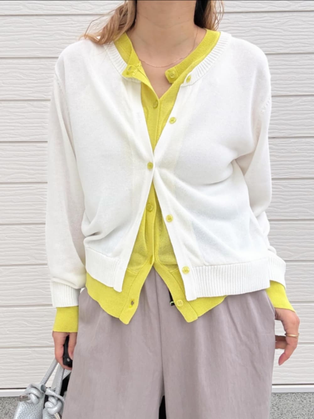 ベージュ系のその他パンツ、ホワイト系のカーディガン/ボレロ、シルバー系のトートバッグを着用したレディースの春コーディネートの4枚目の写真