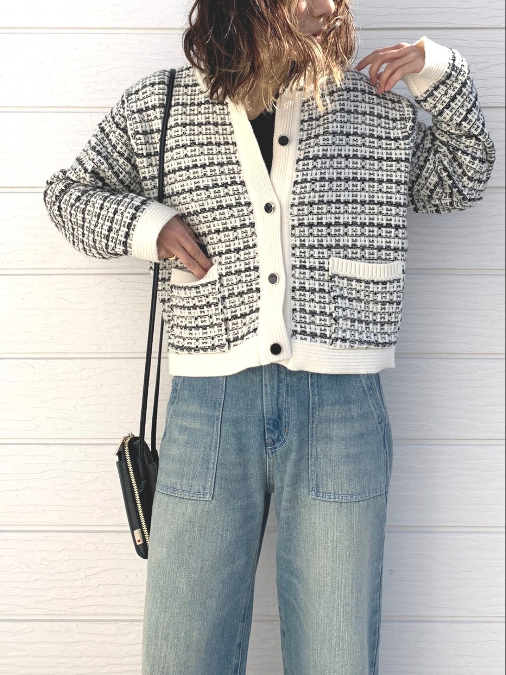 ブルー系のデニムパンツ、ホワイト系のカーディガン/ボレロ、ブラック系のショルダーバッグを着用したレディースの冬コーディネートの4枚目の写真