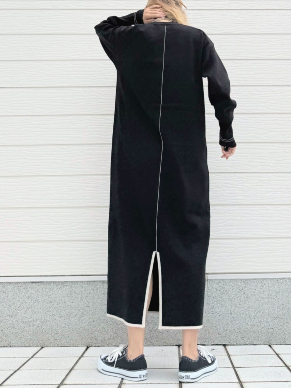 ブラック系のスニーカー、ブラック系のワンピース、ホワイト系のストール/ショールを着用したレディースの秋コーディネートの4枚目の写真