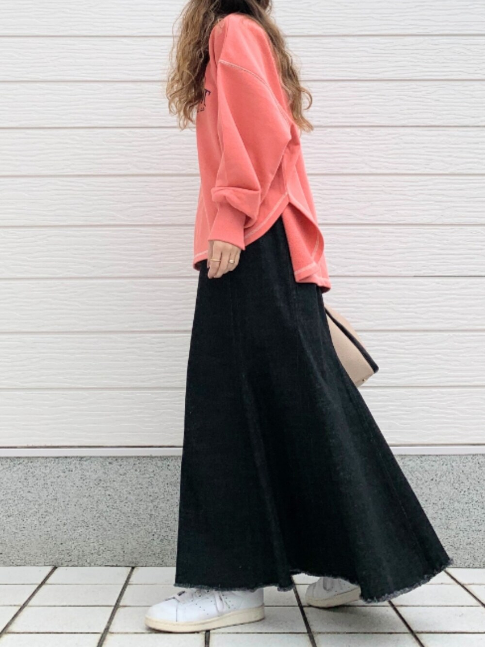 ブラック系のデニムスカート、ホワイト系のスニーカー、ベージュ系のトートバッグを着用したレディースの秋コーディネートの2枚目の写真