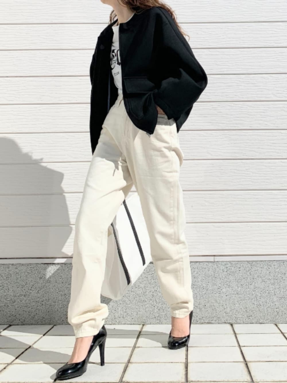 ホワイト系のトートバッグ、ホワイト系のTシャツ/カットソー、ホワイト系のデニムパンツを着用したレディースの冬コーディネートの2枚目の写真