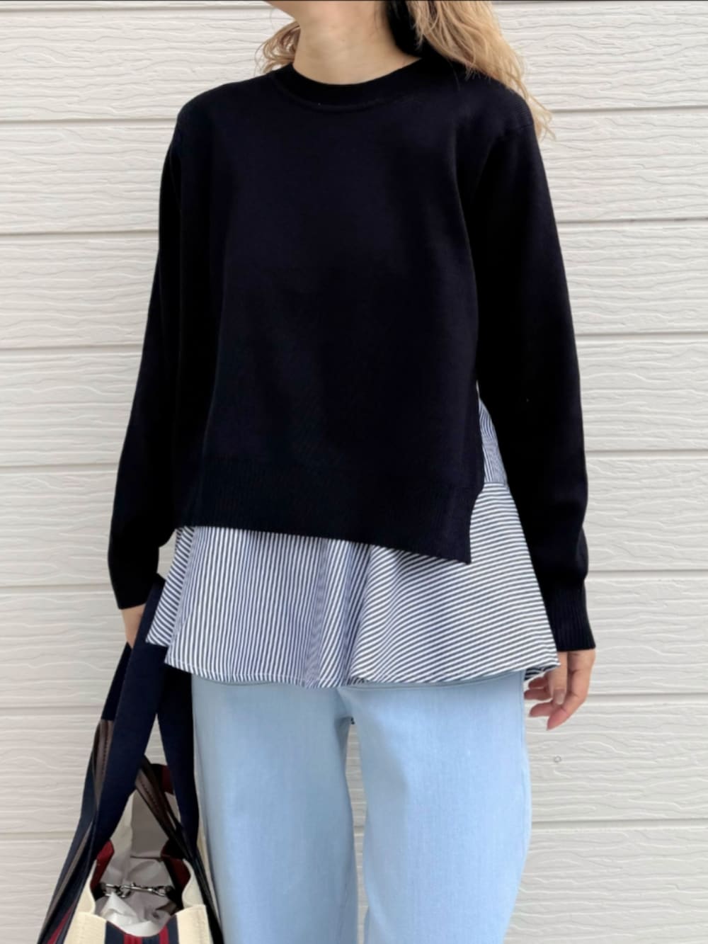 ブルー系のデニムパンツ、ブルー系のニット/セーター、ブラック系のサンダルを着用したレディースの春コーディネートの4枚目の写真