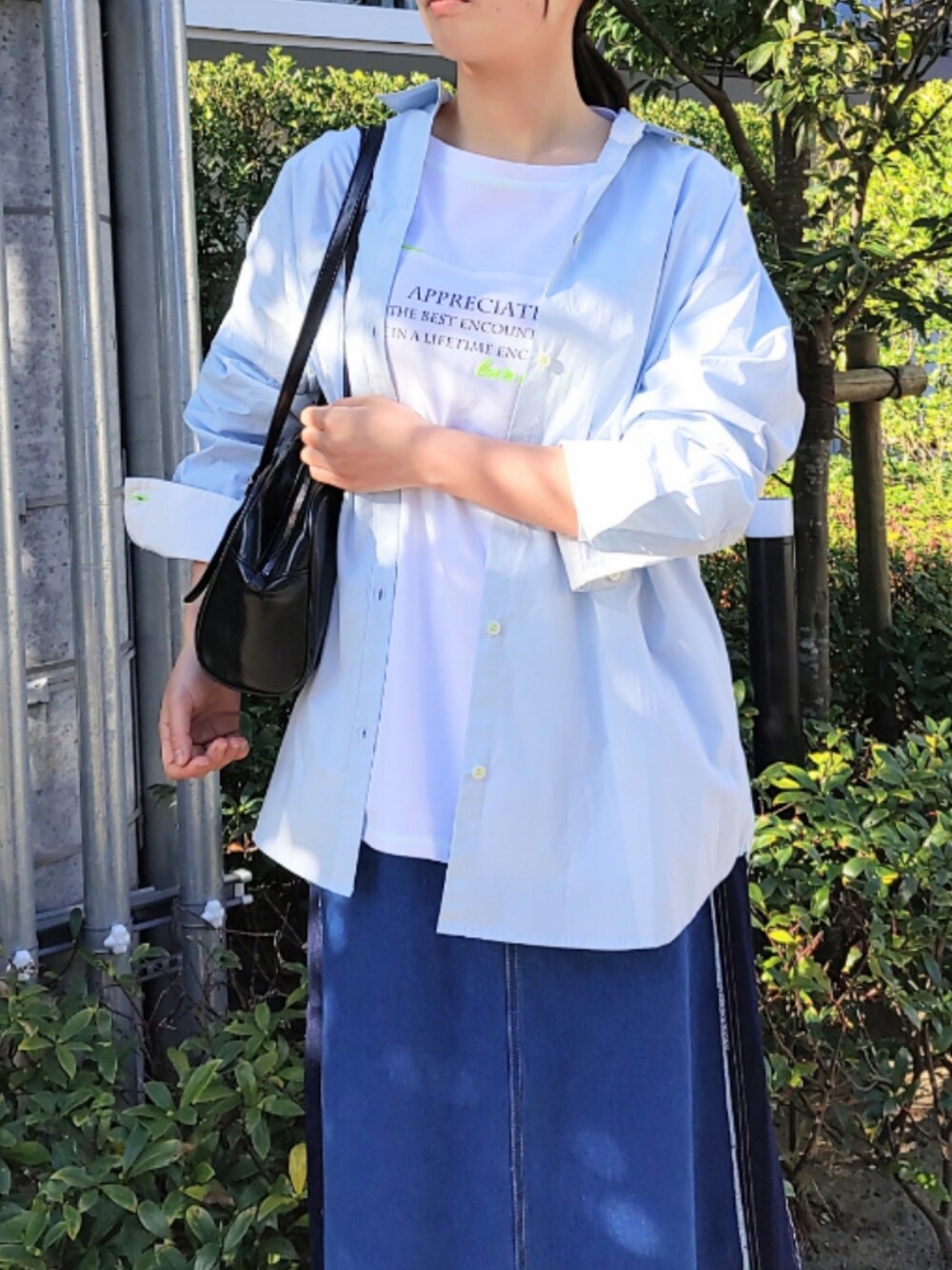 ブルー系のデニムスカート、ホワイト系のスニーカー、ホワイト系のTシャツ/カットソーを着用したレディースの冬コーディネートの4枚目の写真