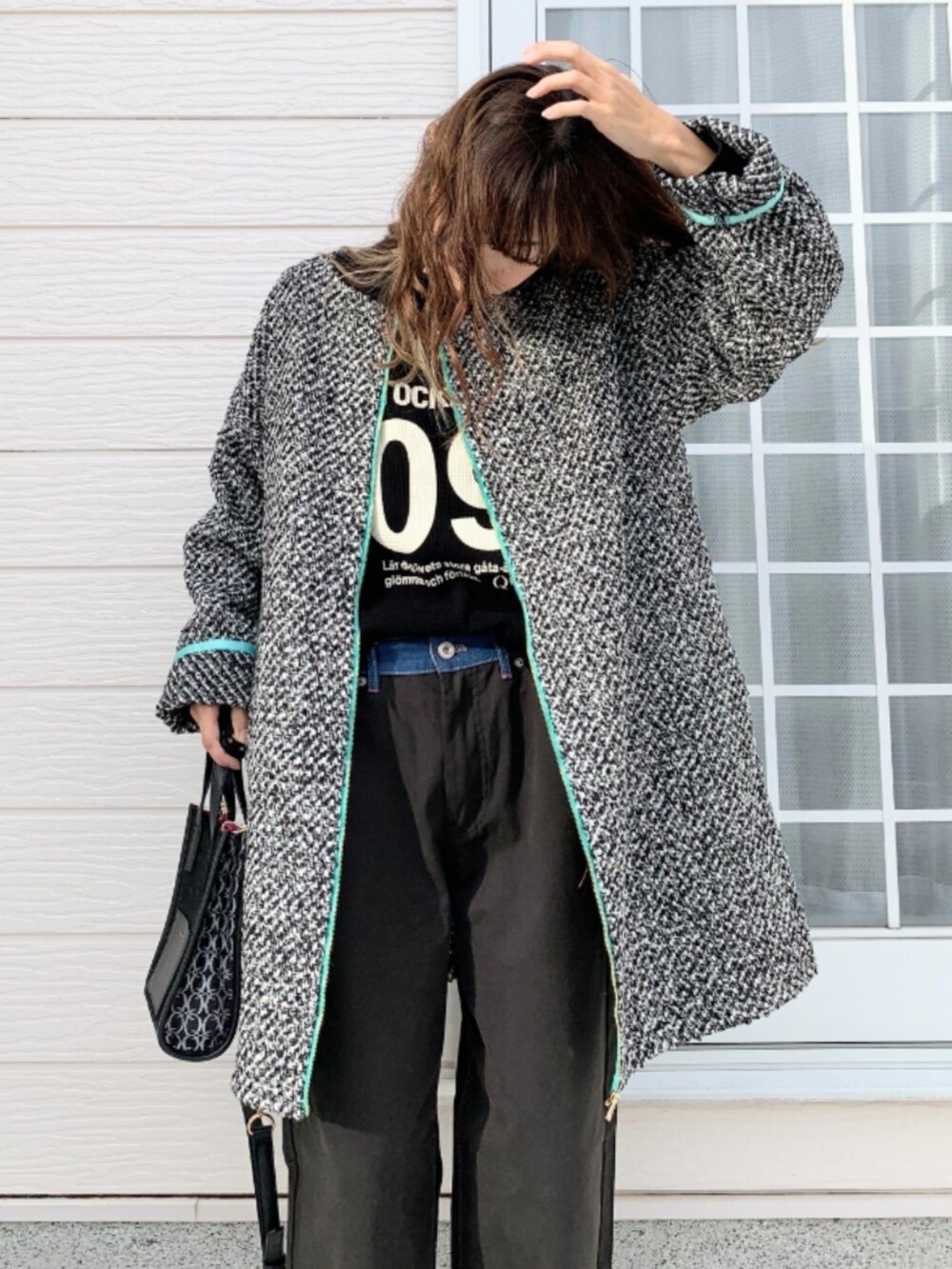 ブラック系のデニムパンツ、ブラック系のショルダーバッグ、ブラック系のTシャツ/カットソーを着用したレディースの秋コーディネートの4枚目の写真