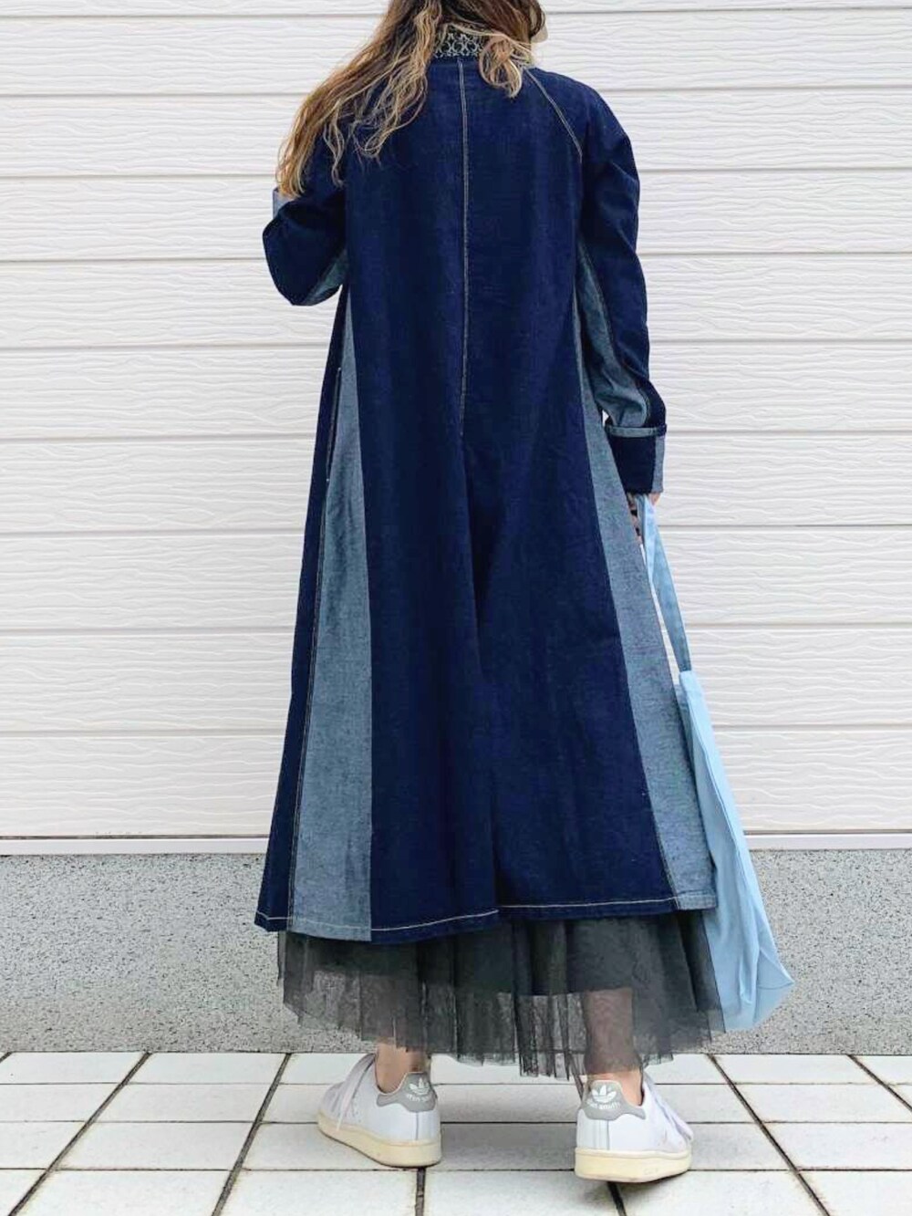 ブラック系のスカート、ホワイト系のスニーカー、ホワイト系のTシャツ/カットソーを着用したレディースの秋コーディネートの4枚目の写真
