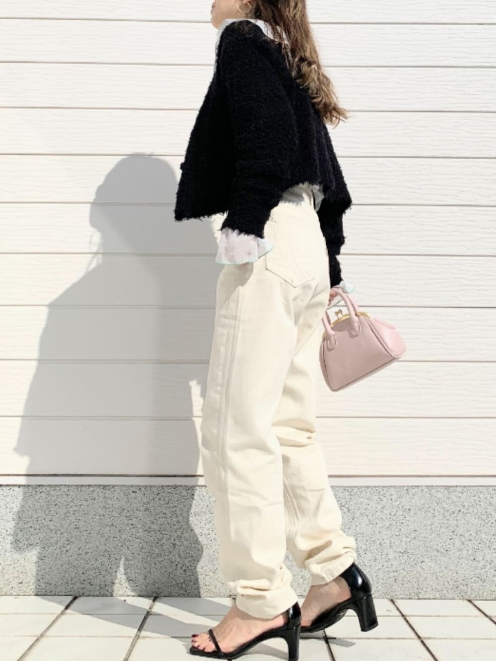 ピンク系のショルダーバッグ、ホワイト系のデニムパンツ、ブラック系のカーディガン/ボレロを着用したレディースの春コーディネートの2枚目の写真