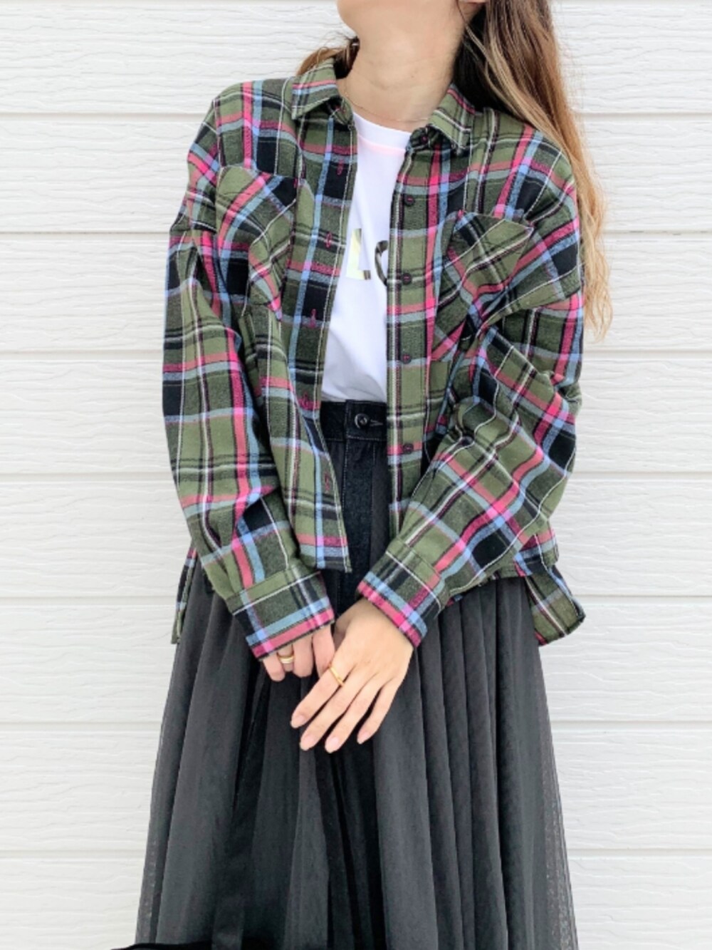 ブラック系のスカート、ホワイト系のスニーカー、ホワイト系のTシャツ/カットソーを着用したレディースの秋コーディネートの3枚目の写真